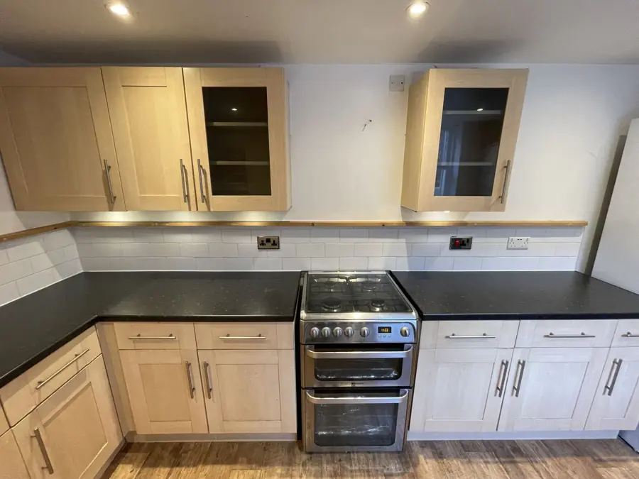 Finished rental kitchen with black worktops